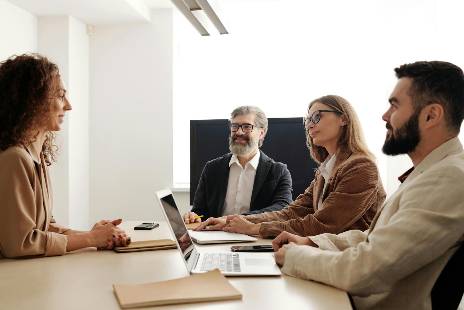 Man and Woman Sitting on Chair in Front of Macbook Pro