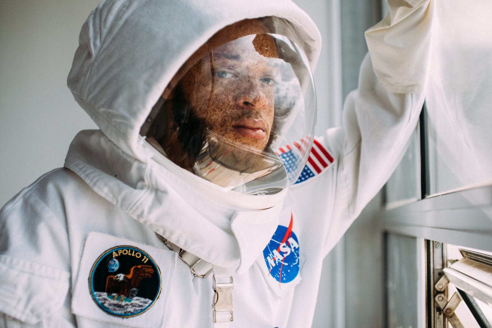 Man In A Space Suit Leaning On A Window